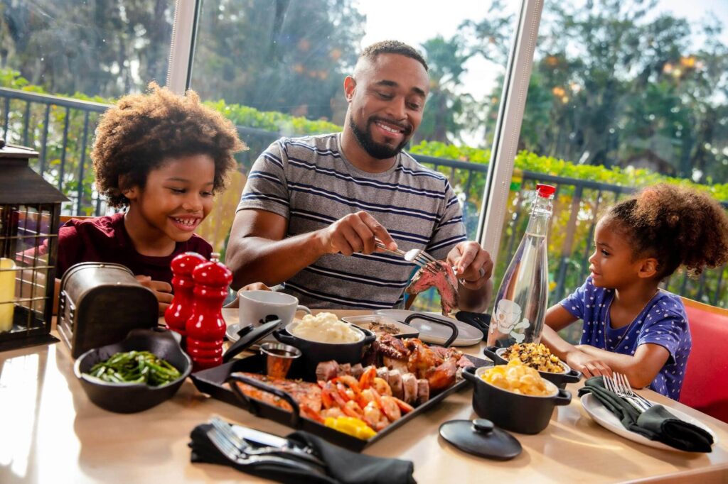 father and kids eating a shared meal at Pirate Island Hotel in Winter Haven, FL