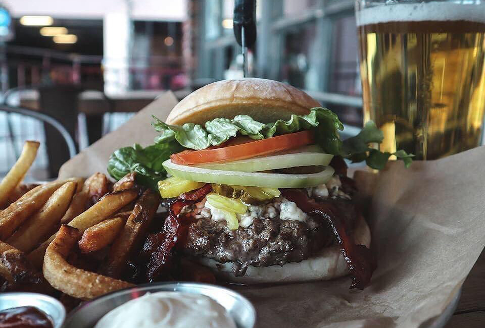 custom burger and fries on the outside patio at looseys