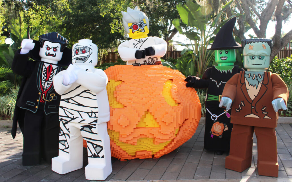 LEGOLAND characters in front of a Lego pumpkin.