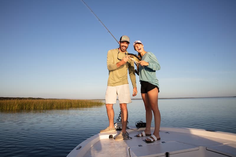 Man and woman holding up a fish on the lake at Camp Mack