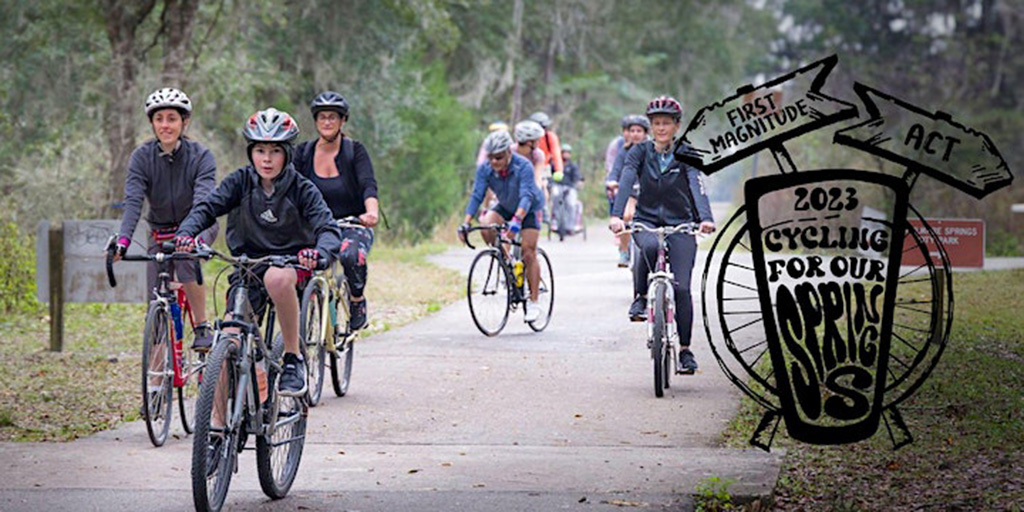 people on bicycles riding on paved trail